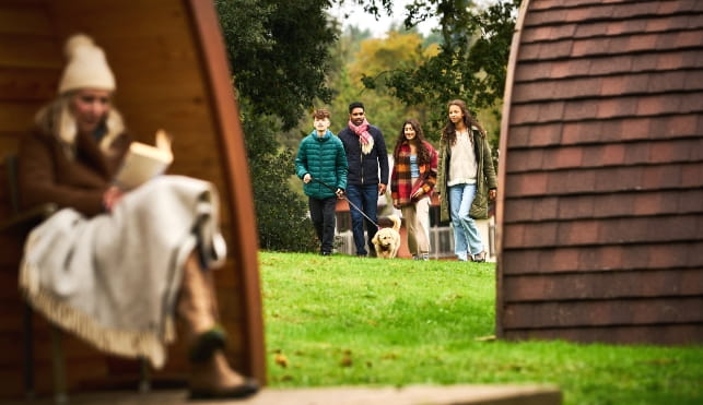 Woman reading a book outside a glamping pod